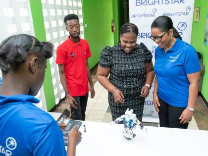Debbie Green (right), general manager of Brightstar Lottery Jamaica, shares a light moment as a camper puts a robot through its paces during the sixth annual Coding and Robotics Rock! Camp presented by Brightstar Lottery. The free two-week programme runs s