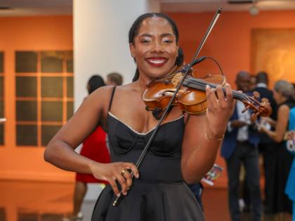 Adding a melodic touch to the evening’s art experience, Dayna Palmer takes a moment from her performance to pose for a photo.