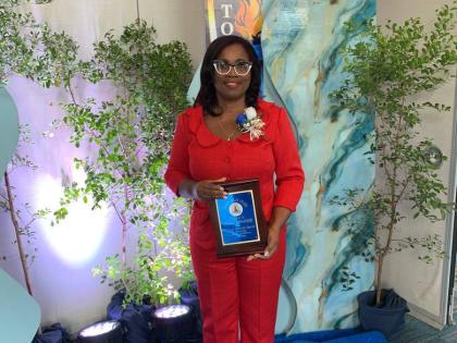 Ann Marie Brown-Burgess, fashion design lecturer at Montego Bay Community College, with her JTA Golden Torch Award for 35 years of service in the education sector.