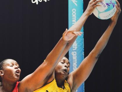 Sunshine Girls goal shooter, Romelda Aiken-George (right), catches a ball during a Commonwealth netball game at the Hydro in Scotland yesterday. Challenging her is Uganda’s Muhameed Haniisha.