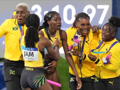 
An absolutely shattered Dejanea Oakley of Jamaica (third left) is mobbed by her teammates after crossing the finish line to win the mixed 4X400-metre relay at the Commonwealth Games in Glasgow, Scotland, yesterday.