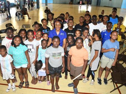 Campers at the YMCA Summer Camp pose for a group photo with Rose Miller, financial education consultant at the JN Foundation, following an interactive financial literacy session on budgeting, saving and investing.