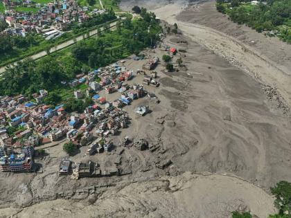 Damaged houses stand precariously near the swollen, debris-choked banks of the Trishuli River after flash floods in Nepal's Nuwakot district on Wednesday. - AP photo