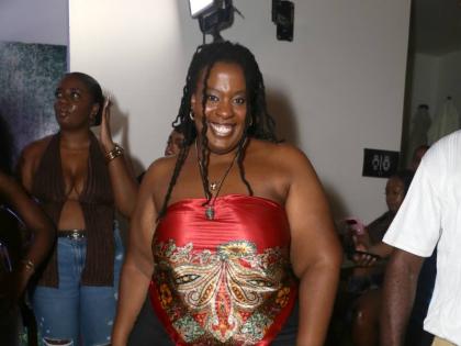 Vocalist Courtni dons a red-and-gold ornate scarf-print strapless top.