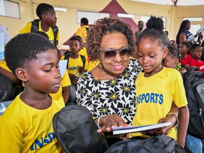 Minister of Culture, Gender, Entertainment and Sport, Olivia Grange, interacts with participants in the INSPORTS Summer Youth Camp 2026, Allan Parkes (left) and Alliandrea Morris, during the camp's recent Closing and Awards Ceremony at Eltham High School i