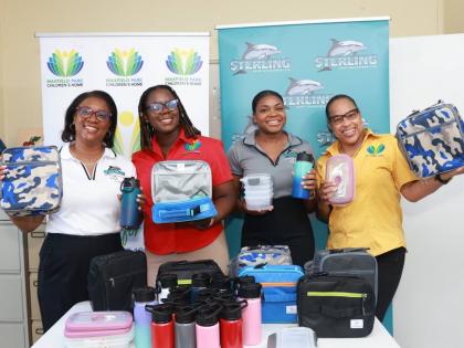 Representatives of Sterling Asset Management Ltd. and Maxfield Park Children’s Home showcase a selection of the donated items, including lunch boxes, insulated water bottles and food containers, provided to support the children of the home ahead of the n