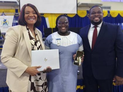 Anastacia Williams shows her phone that she used to do her assignments along with her new laptop presented to her Dr Audrey Gregory, senior vice president of by AdventHealth, and Donmayne Gyles, president and CEO of Andrews Memorial Hospital.