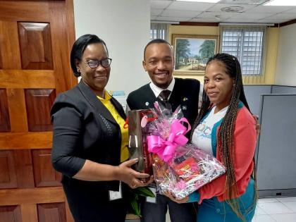Paulette Chambers-Salmon (left), recently retired business relationship and sales manager, JN Bank May Pen branch and Old Harbour MoneyShop, presents Michael Bernard, senior sales officer and Tanicia Fisher, sales officer, with tokens of appreciation for t