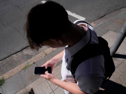 FILE - A teenage boy uses his phone in Sydney, Nov. 8, 2024. (AP Photo/Rick Rycroft, File)