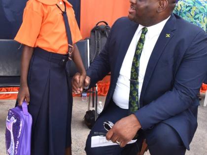 Parliamentary Secretary in the Ministry of Education, Skills, Youth and Information, Senator Marlon Morgan, greets student of Edward Seaga Primary School in Kingston, Ajonieke Whittingham, during a visit to the institution's North Street campus on Monday, 