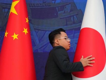 Staff organise flags from China, left, and Japan before the start of the 28th ASEAN Plus Three Summit in Kuala Lumpur, Malaysia, on October 27, 2025. 