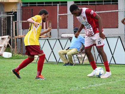 St. James High School’s Dondre Vernon (right) tries to shake the attentions of Muschett High’s Devantae Williams during their ISSA daCosta Cup preliminary round football game at Jarrett Park yesterday.