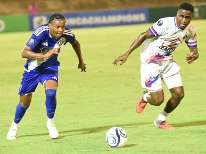 Mount Pleasant Football Academy’s Nickalia Fuller (left) and Portmore United’s Akeem Mullings compete for the ball during their Concacaf Caribbean Cup football match at the National Stadium recently. Both teams are still in with a last-ditch shot at a 