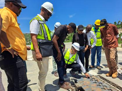 Works Minister Robert Morgan (third left) looks on as Gui Hongsheng (fourth left), project manager from China Harbour Engineering Company, showcases a section of the Montego Bay Bypass which is still under construction, during a tour of the bypass and othe