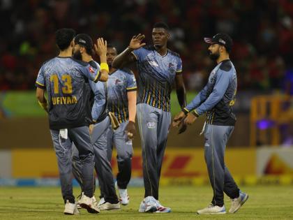 Antigua and Barbuda Falcons paceman Alzarri Joseph (second right) is congratulated by teammates for taking one o his four wickets during their Republic Bank Caribbean Premier League cricket game against the Guyana Amazon Warriors at the Providence Stadium 