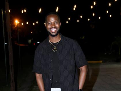 Danar ‘Dan Dan’ Royal pairs a casual black short-sleeved button-down shirt with light coloured pants and white low tops.