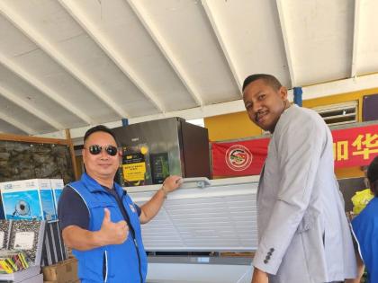 Ben Shen (left), chairman of the Supervisory Board of the Jamaica Chinese Federation, shows Kew Park Primary School Principal Ramon Bremmer a deep freezer donated to the Eastern Westmoreland school. The Federation responded to an appeal for assistance with