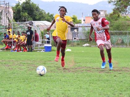 Muschett High’s Jeovani Fagan (left) and St James High’s Deyon Bailey chase the ball  during their ISSA daCosta Cup preliminary round game at Jarrett Park on Tuesday. 