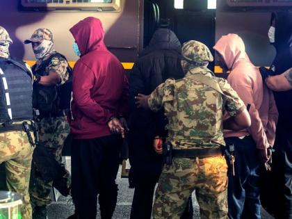 Members of the elite tactical police unit escort six Nigerian nationals being extradited to US for participating in romance scams, in Cape Town, South Africa, Friday, September 11, 2026.