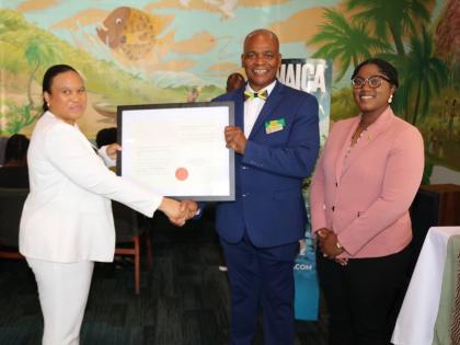 Lishann Salmon, chargé d’affaires at the Embassy of Jamaica, formally presents Jamaica’s honorary consul to Richmond, Lieutenant Karl M. Bryan, with his writ of commission during his installation ceremony at Carena’s Jamaican Grill in Richmond on Su