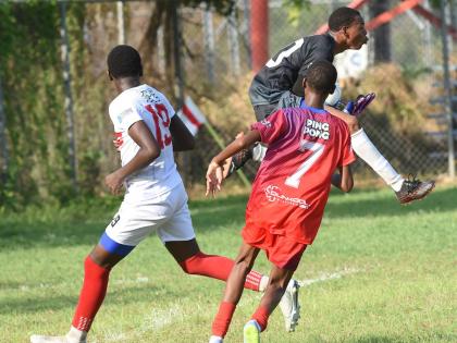 Bridgeport High goalkeeper Malik Higgins (right) gathers the ball ahead of Oneil Patrick (left) from Camperdown High during their Manning Cup football clash at the Dunbeholden playfield on Wednesday. Also in the picture is Qwayne Brown  of Bridgeport.