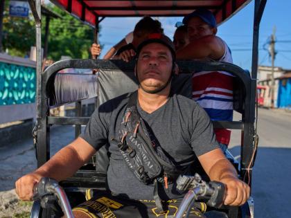 
Liexer De La Cruz drives his tricycle with customers in Minas, Cuba’s Havana province, September 4.