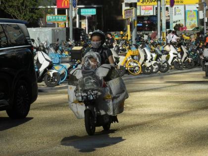 A woman ride an electric bike in Beijing.