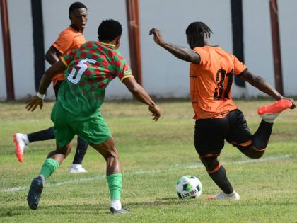 Alton Lewis (right) of Tivoli Gardens prepares to take a shot during yesterday’s Jamaica Premier League match against Humble Lion at Edward Seaga Sports Complex. At left is Shawn Campbell of Humble Lion. 