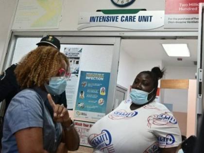 Minister of Education, Skills, Youth and Information, Senator Dr Dana Morris Dixon (left) shares in conversation with the mother of a child who was severely injured after a boulder fell on her on Friday, September 11, while on her way to school in Breadnut