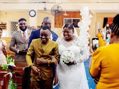 Following the ceremony, newly-weds Tadjé and Patrice Dixon take their first walk as husband and wife.