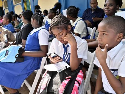 Twins Kendra and Kai Lall, (right) 8th  graders coming from Hydel seated with students at the ceremony of the opening of the merged Hydel Cumberland High in St Catherine on September 7. 
