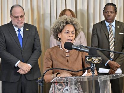 Deputy Spokesperson on Education Dr Maziki Thame addresses a press conference on Monday as Opposition Leader Mark Golding (left) and Education Spokesperson Damion Crawford (right) look on.