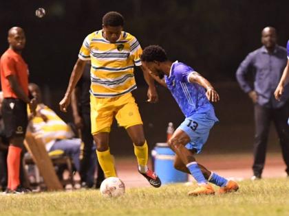 Treasure Beach’s Daniel Hardy (left) tries to get by Molynes United’s Shavaun Reid during their Jamaica Premier League football game at Stadium East yesterday.