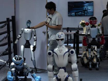 A worker gets a robot ready for demonstration at a booth for leading Chinese commercial humanoid robotics firm Unitree Robotics during the World AI Conference in Shanghai, China, on July 18, 2026. 