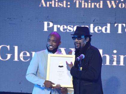 Glen Washington (right) receives Grammy Certificates for his contributions to Capleton’s Still Blazin’ and Third World’s Ain’t Givin’ Up. Joel Laing, the event’s sponsorship manager, makes the presentation.