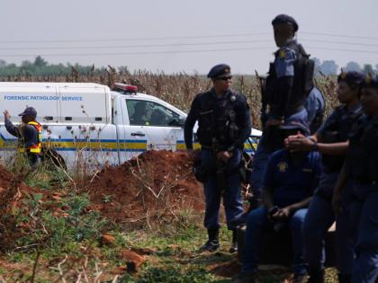 Forensic investigators work at the site where the body of a woman was discovered on the outskirts of Johannesburg, South Africa, Thursday.