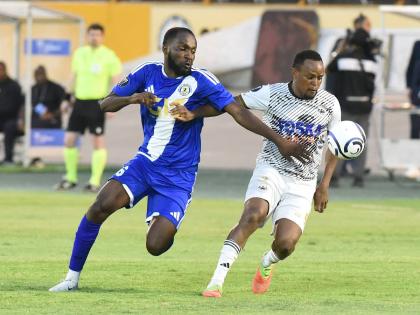 Cavalier SC’s Nicholas Hamilton (right) comes under pressure from Portmore United’s Clifford Thomas during their Concacaf Caribbean Cup football match at the National Stadium yesterday.