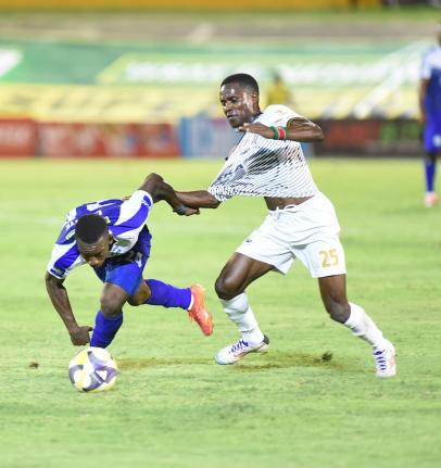 
Franco Celestin (left) from Mount Pleasant tugs on the shirt of Jahmilio Rigters from Cavaliers during action from last season’s Jamaica Premier League final at the National Stadium.