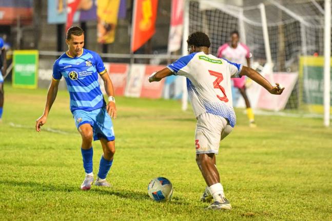 Dunbeholden’s Ricardo Beckford (right) tries to dribble by Molynes United’s Leyvan Rigg during their Jamaica Premier League encounter at the Waterhouse Stadium yesterday. Dunbeholden won 2-0. 