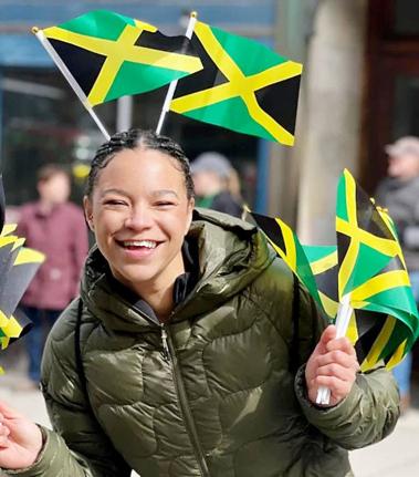 Mica Moore waves Jamaican flags after securing her Jamaican citizenship.