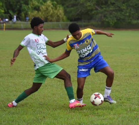 Rusea’s High School goalscorer Maliek Headed (right) tries to evade the tackle by Frome Technical High School’s Jevani Plummer during their ISSA daCosta Cup match at the Colin Miller Sports Complex on Tuesday. Rusea’s won 3-1 after the second half of