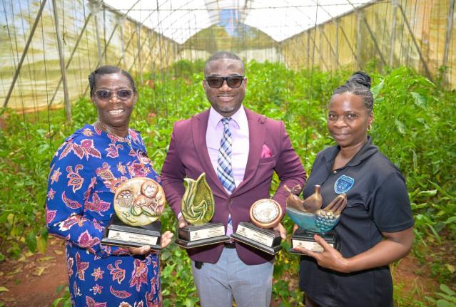 Principal of the Manchester-based Bethabara Primary School, Cecil Hamilton (centre), along with Vice Principal Ritta Evans Lowe (left), and teacher, Dionne Salkey Francis, display trophies won by the school for its high-quality greenhouse crops and value