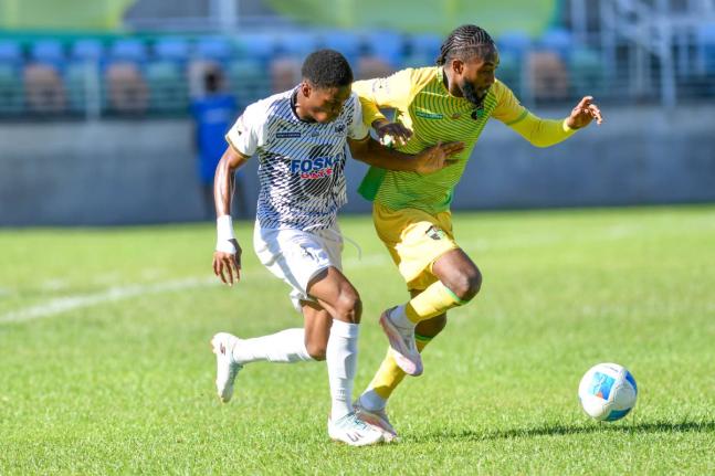 Kevoan McGregor (left) of Cavalier fights to gain possession of the ball from Jhanni Flemmings of Treasure Beach during their Jamaica Premier Leage match  at Sabina Park yesterday. Cavalier won 2-1. 