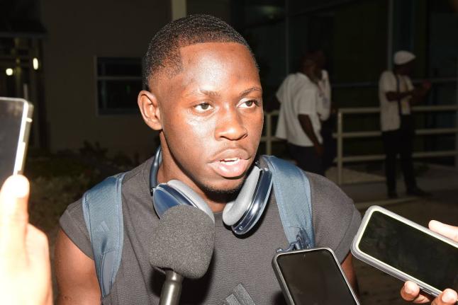 Oblique Seville talks with members of the media on his arrival at the Norman Manley International Airport from the Tokyo World Athletics Championships where he won gold in the men's 100 metres.