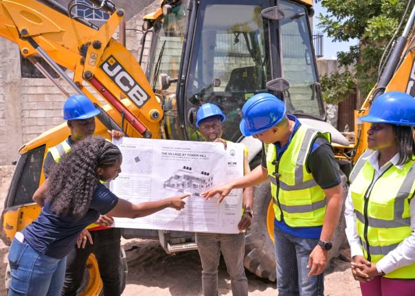 Prime Minister Dr Andrew Holness (second right), is shown the plan for the ‘Village at Tower Hill’ development by Roni-Kaye McLaren, architectural designer, during the contract signing and ground breaking ceremony at the project site on June 13.
