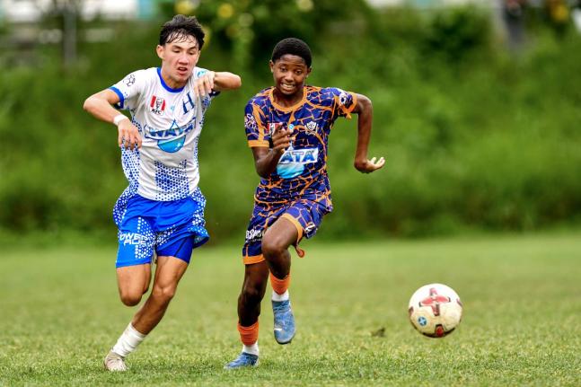 Hillel Academy’s Miles Azan (left) and Dunoon Technical’s Shiloh Roach chase the ball during an ISSA/WATA Manning Cup football match at on September 27. Hillel won 3-2.
