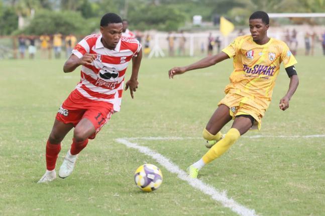Glenmuir High School’s Orel Miller (left) outpaces Garvey Maceo’s Tyreek McKenley during their Zone I ISSA daCosta Cup  match at Glenmuir on October 8. Garvey Maceo came from two goals down to win 3-2. 