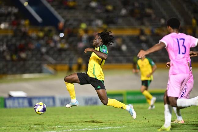 Jamaica's Tyreece Campbell (left) drives past Bermuda's Keziah Martin during their Group B Concacaf World Cup qualification football game at the National Stadium earlier tonight. Jamaica won the game 4-0.