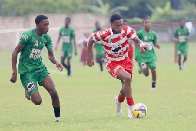 Glenmuir High School’s Oreel Miller (right) dribbles by St Mary Hig School’s Tyrique Banes during their daCosta Cup second-round encounter at Glenmuir yesterday. Miller scored twice in a 10-0 victory.