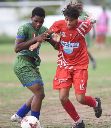 Jovan Russell (left) of Norman Manley High and Campion College’s Luke Stanley battle for the ball during their Manning Cup football match at Campion yesterday.